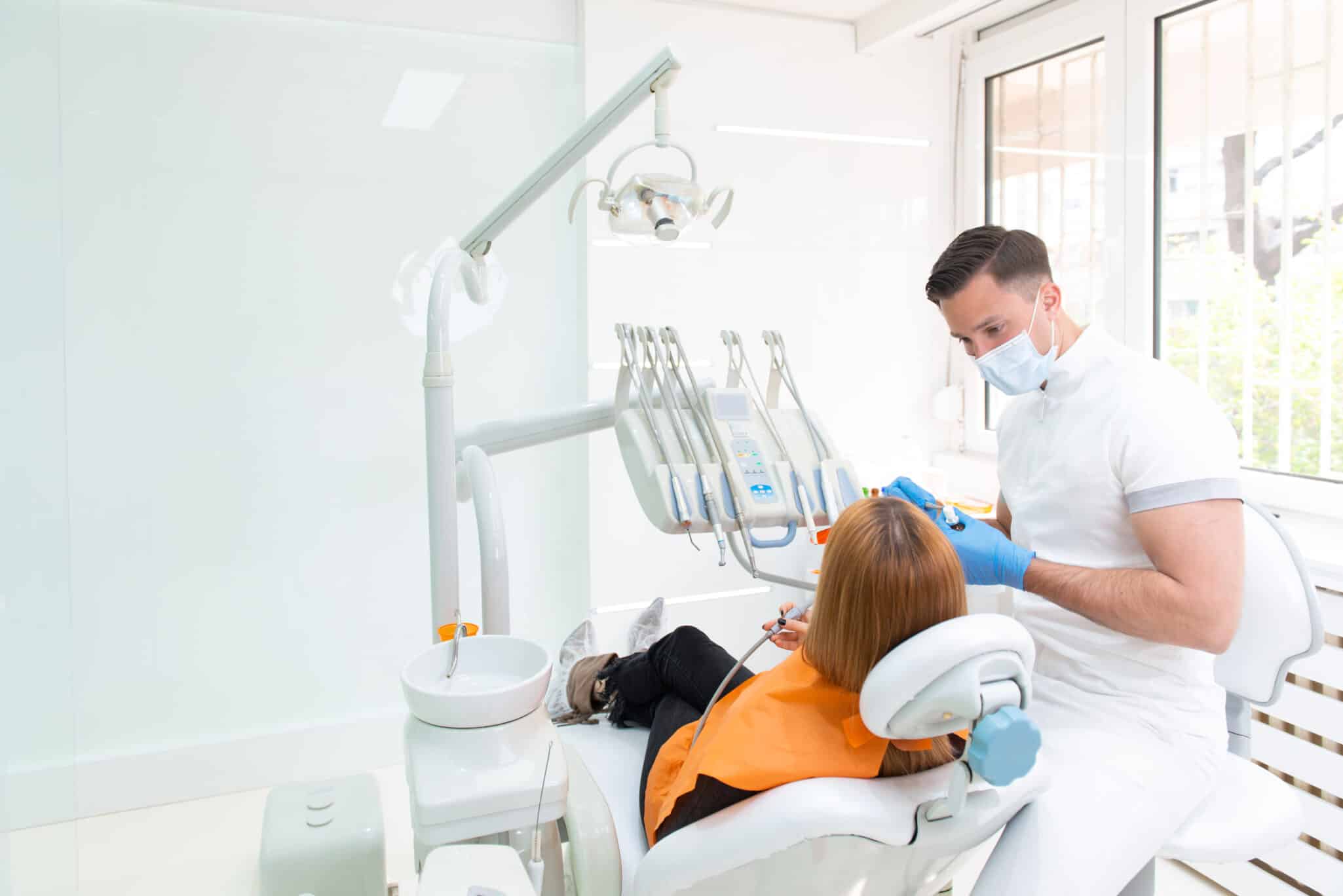 Female patient at dentist office, talking to male dentist