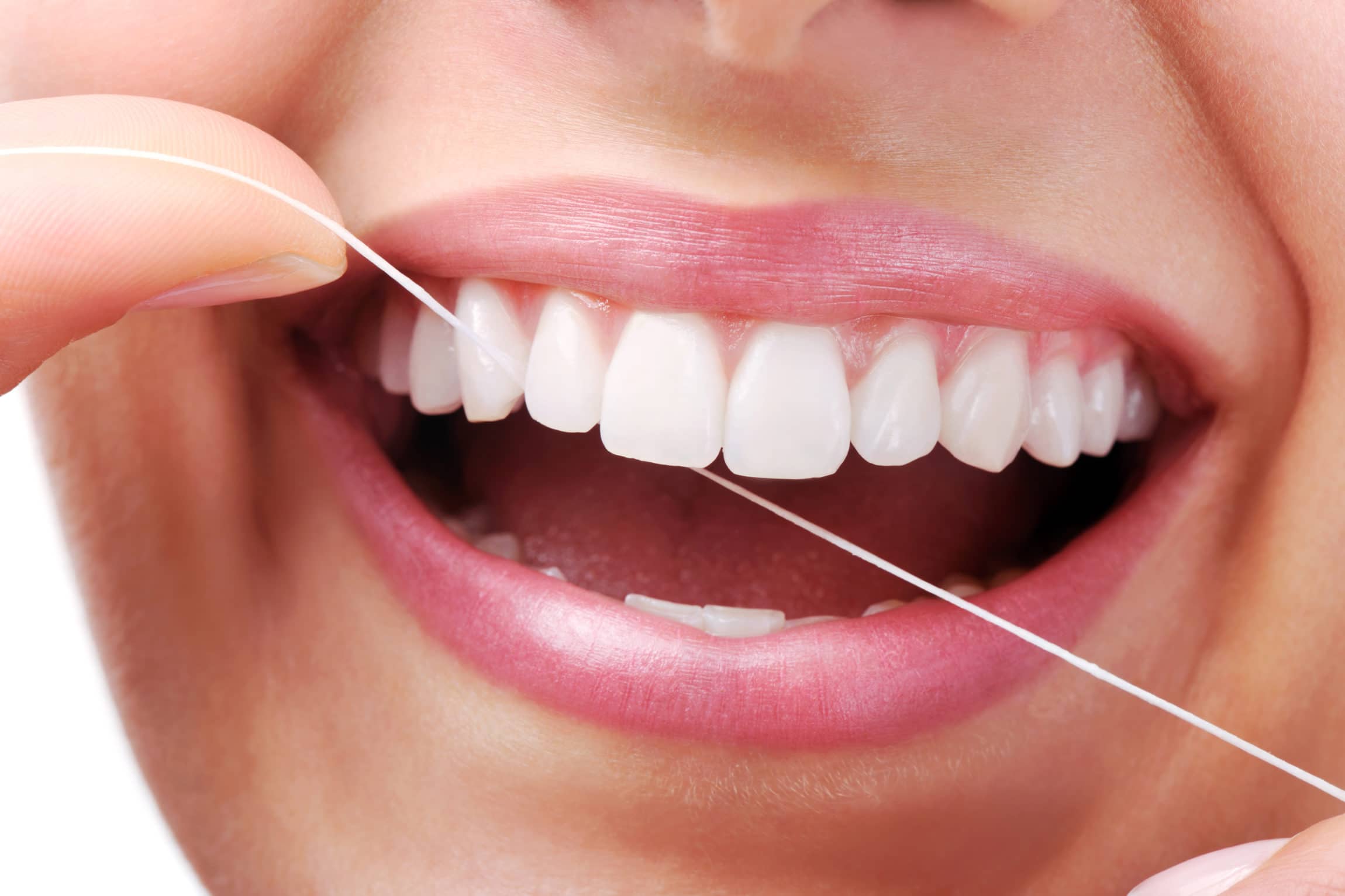close up of woman flossing front teeth